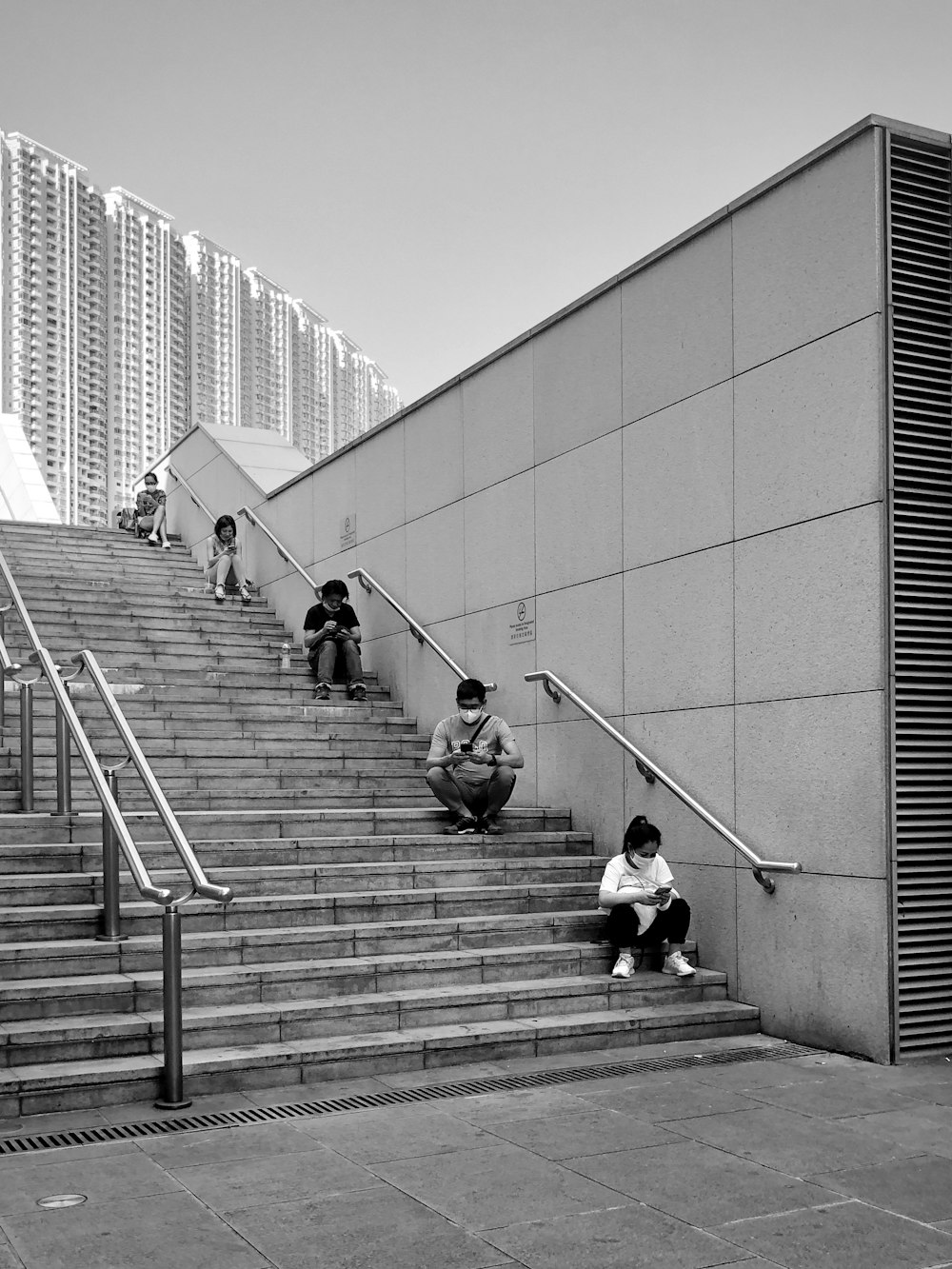 Foto en escala de grises de 2 personas caminando por las escaleras