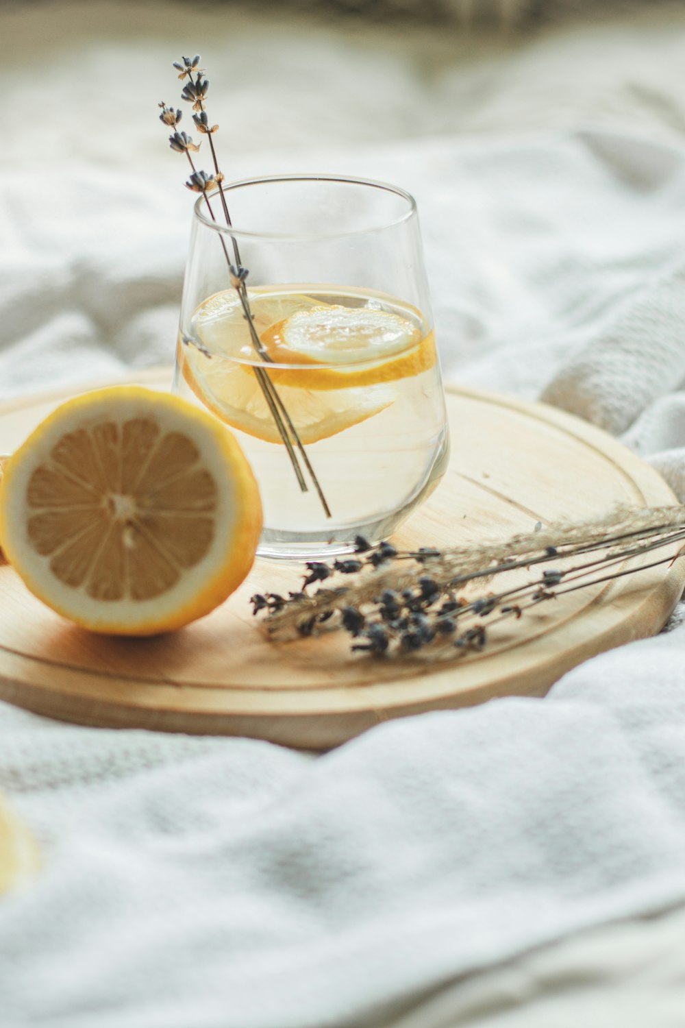 clear drinking glass with lemon on white ceramic plate