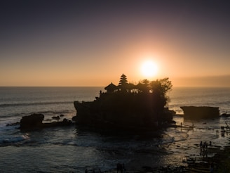 silhouette of trees on island during sunset