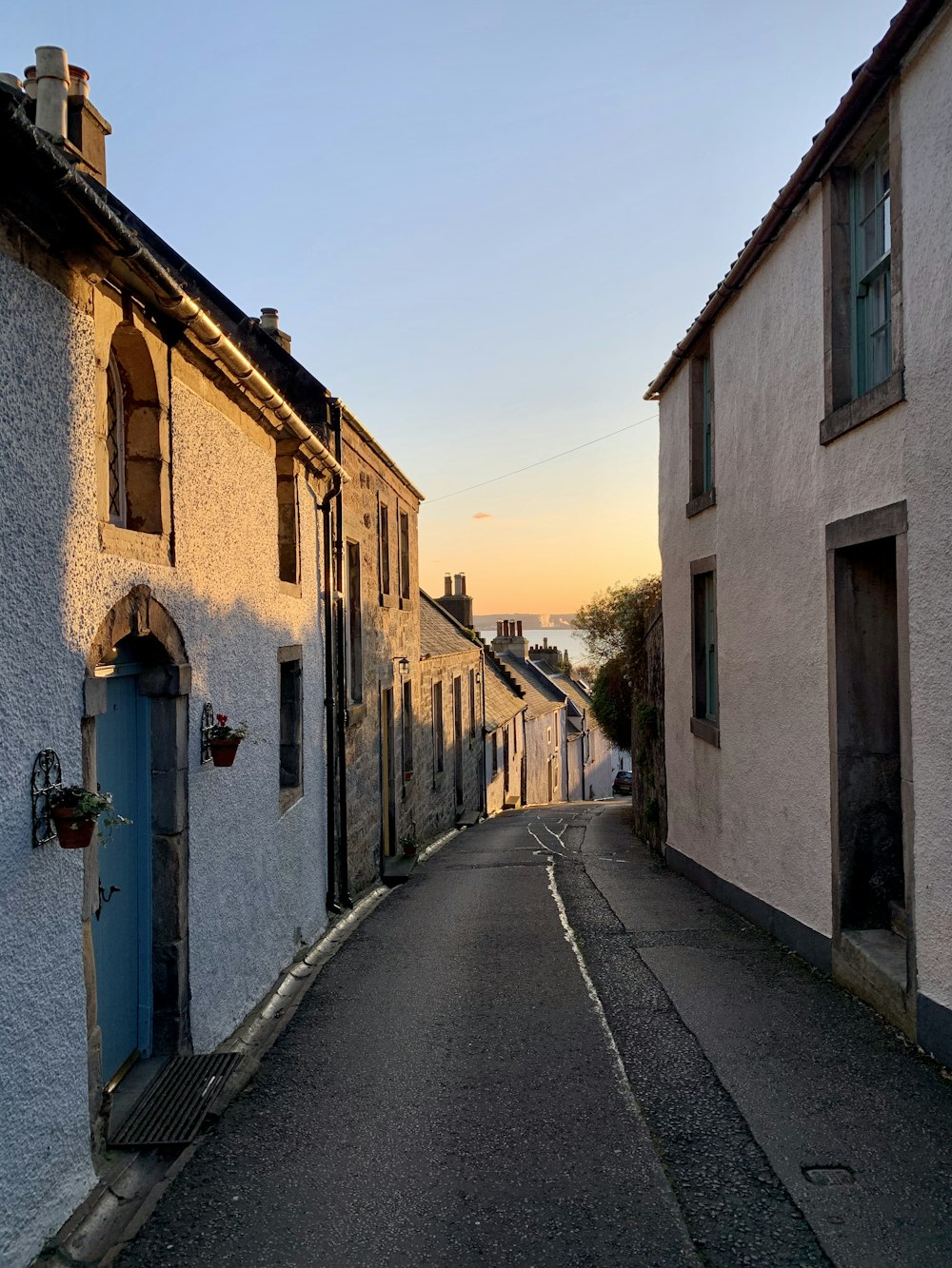 a narrow street with a blue door and windows