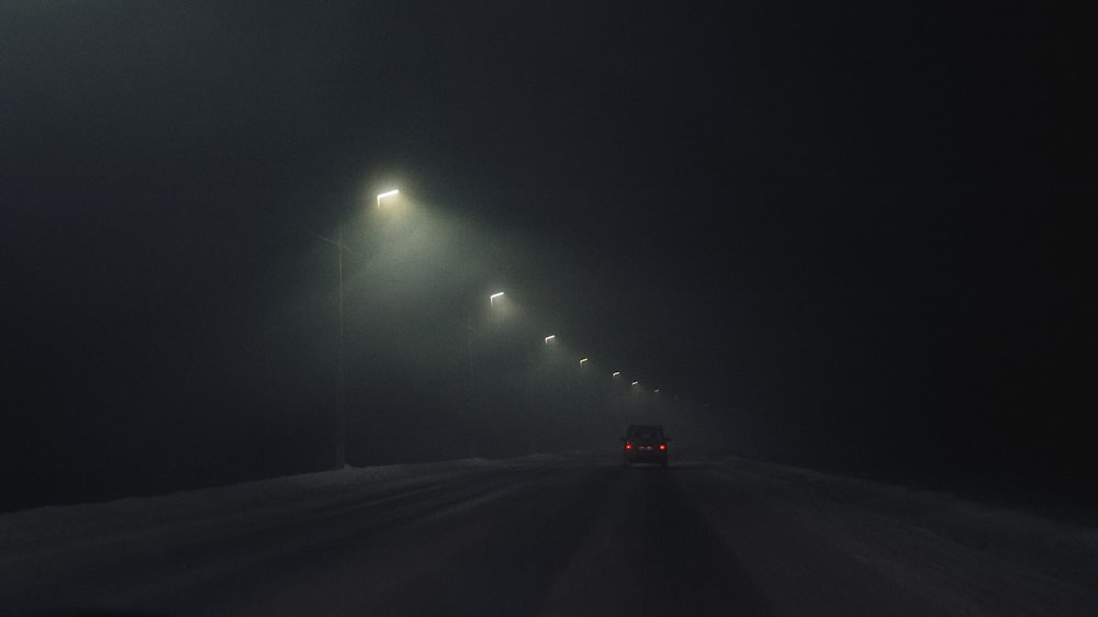 black car on road during night time