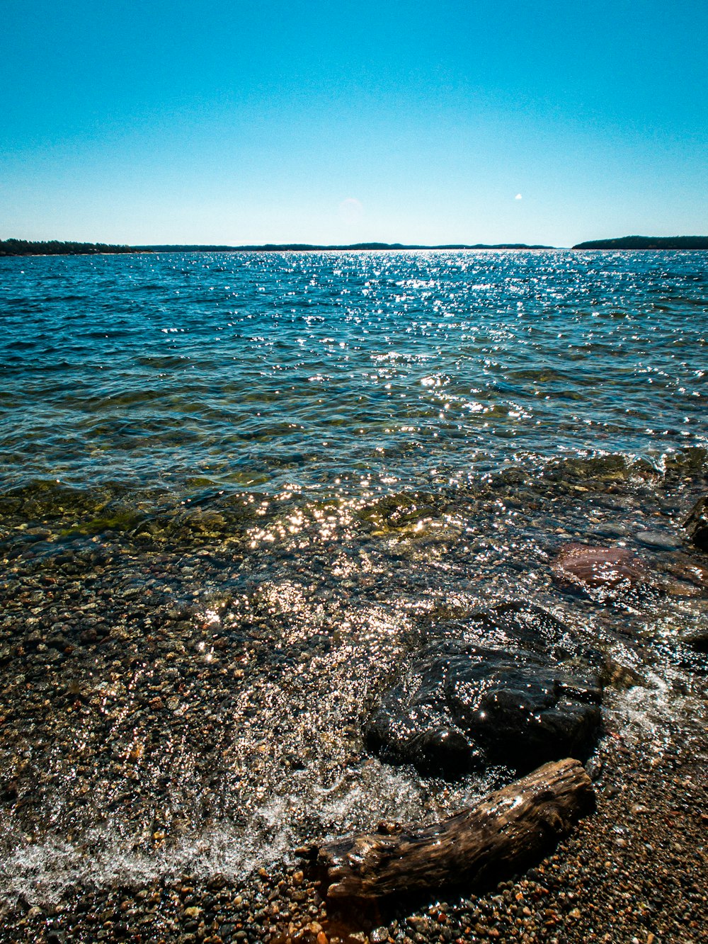 rocce marroni sul mare sotto il cielo blu durante il giorno