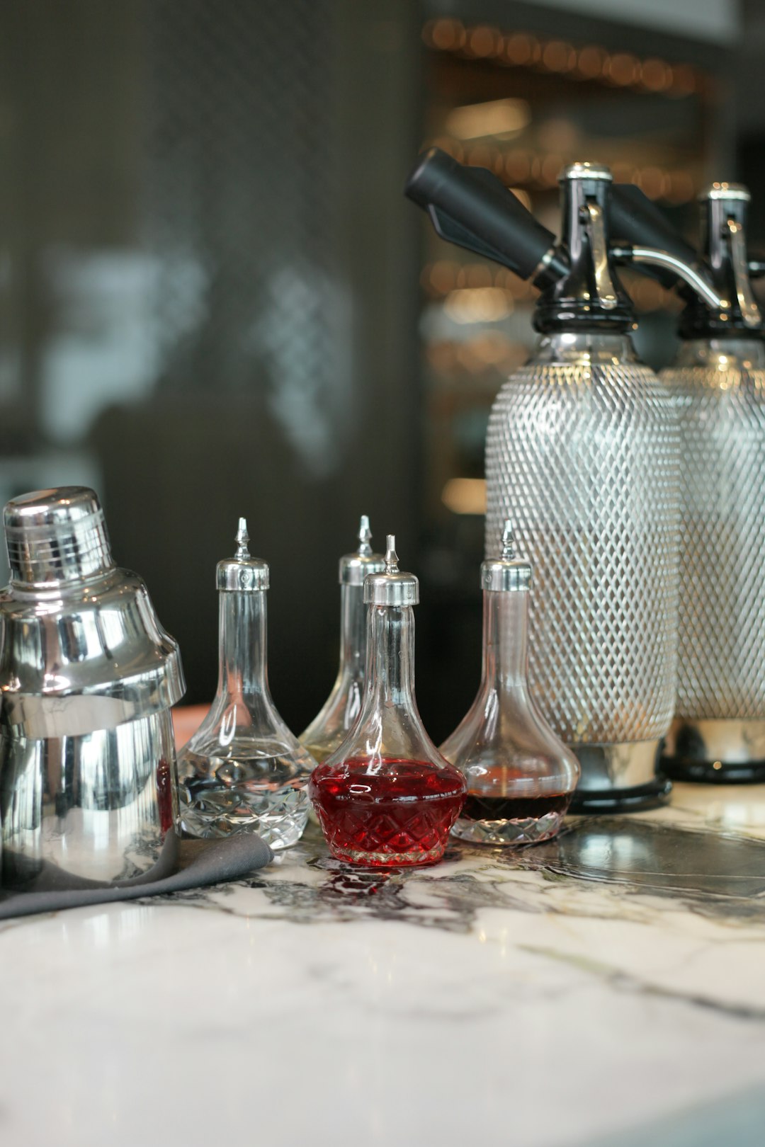 stainless steel condiment shaker beside red wine glass