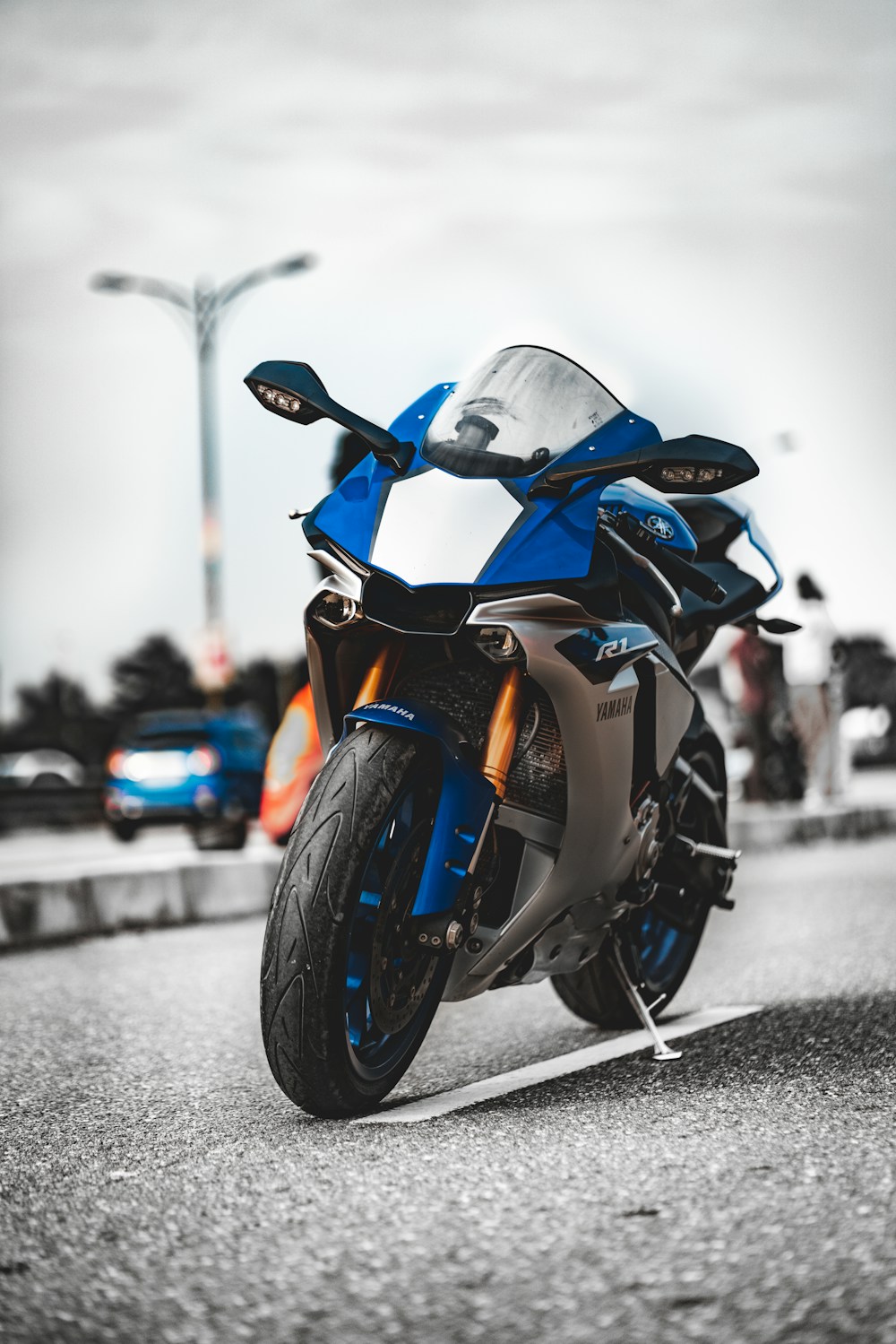 Oranžs un melns sporta motocikls uz ceļa