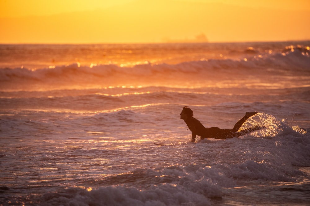 夕暮れ時の浜辺に座る女性