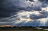 green grass field under blue sky and white clouds during daytime