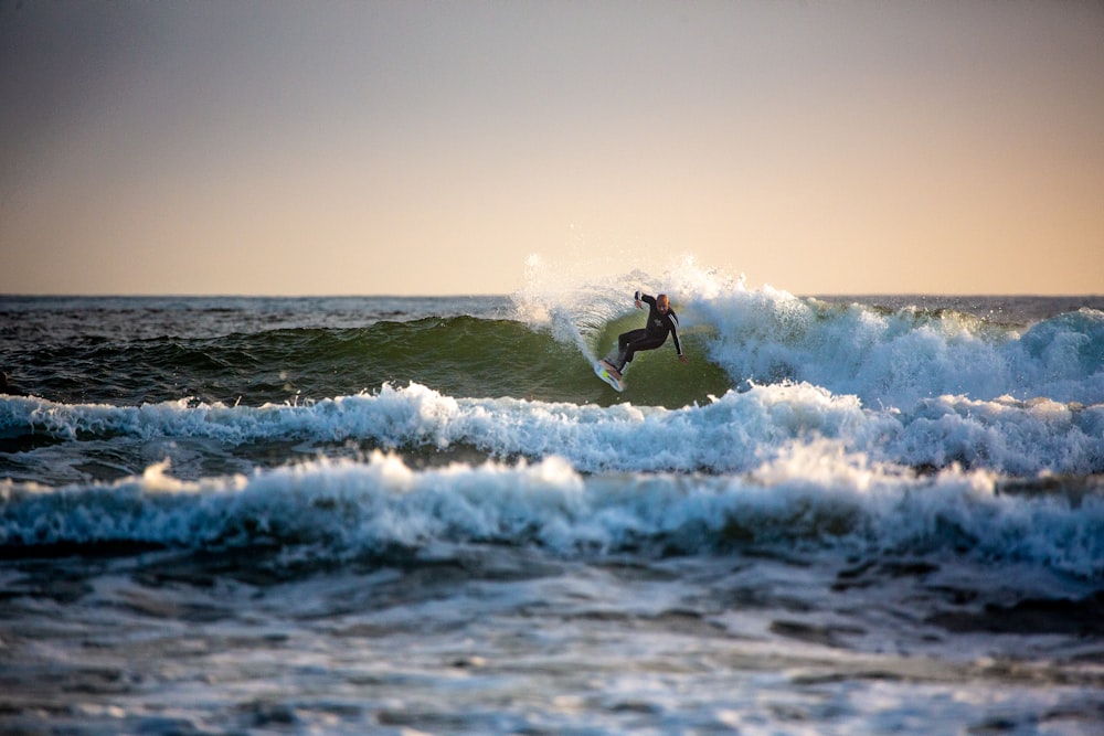 man surfing on sea waves during daytime