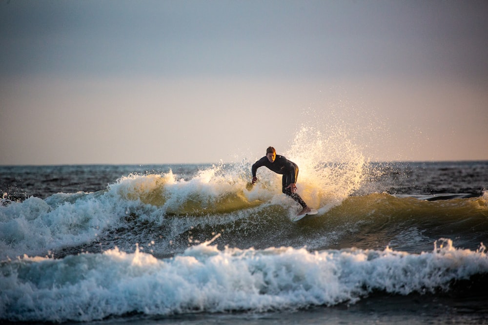 man in black shorts surfing on sea waves during daytime