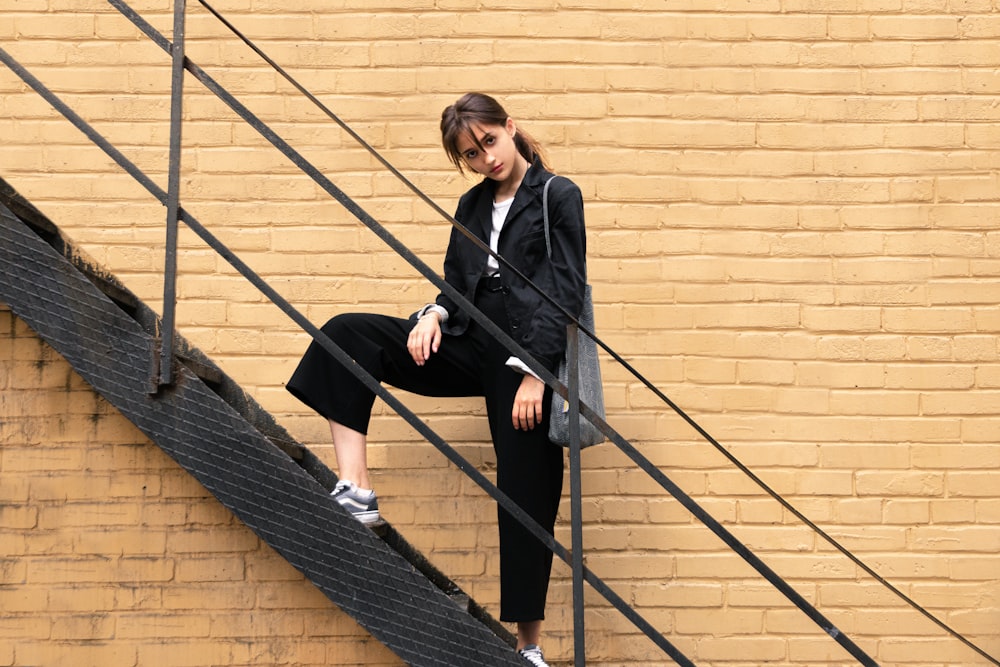 Frau in schwarzem Blazer auf der Treppe stehend