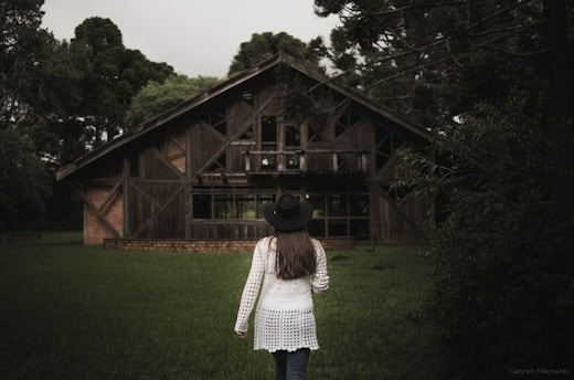 woman in white and black long sleeve shirt and black skirt standing on green grass field