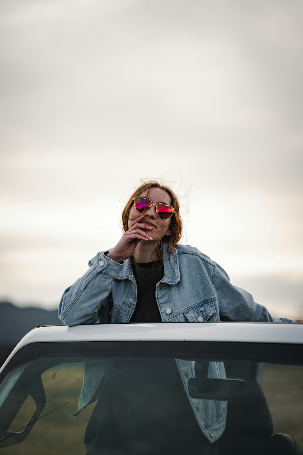 woman in blue denim jacket wearing brown sunglasses