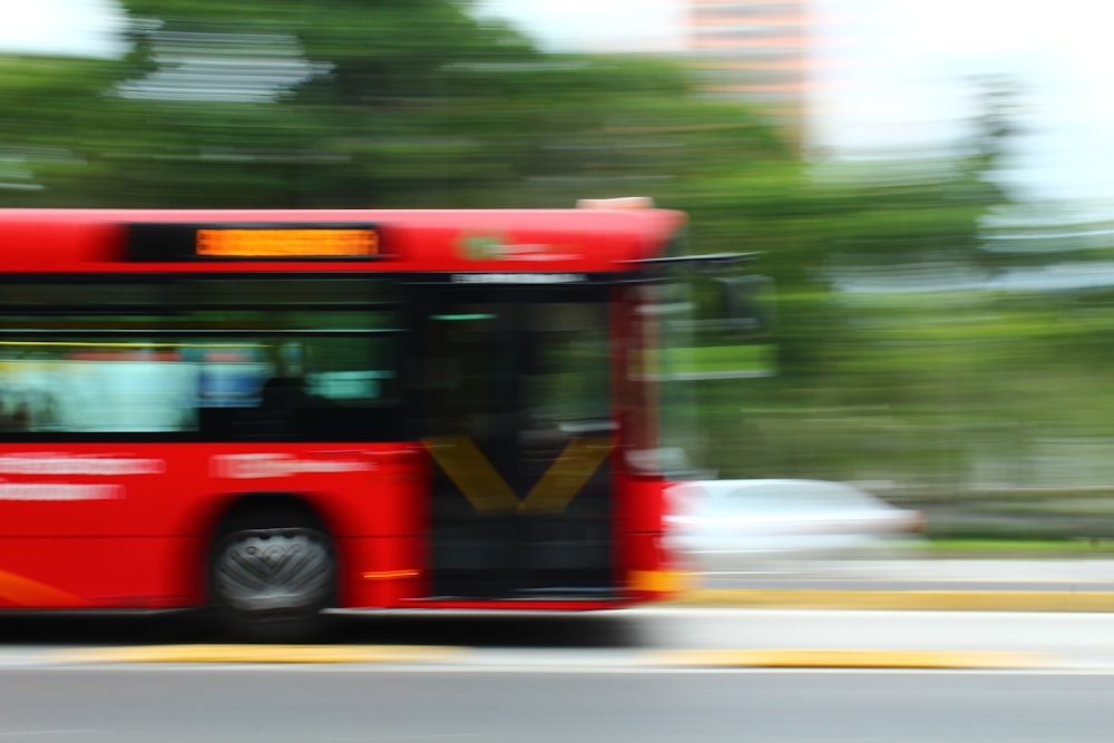 red bus on road during daytime