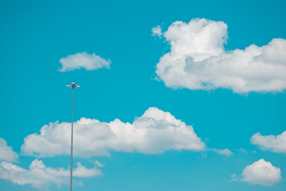 white wind turbine under blue sky and white clouds during daytime