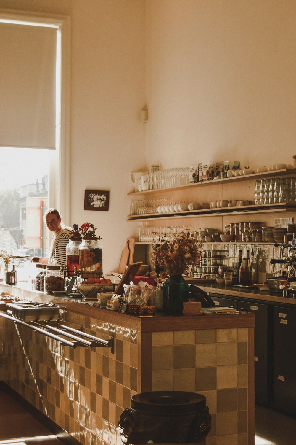 woman in black and white floral dress standing beside counter