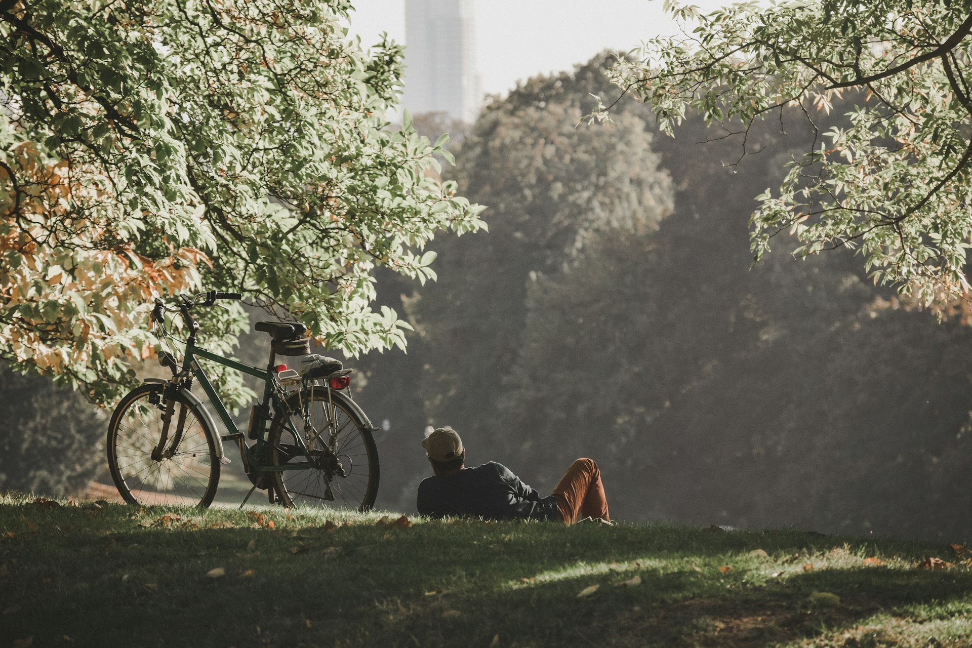 Man relaxing on the grass with his bike on a beautiful day