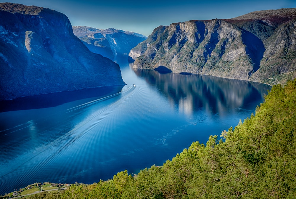 blue lake surrounded by green trees and mountains during daytime