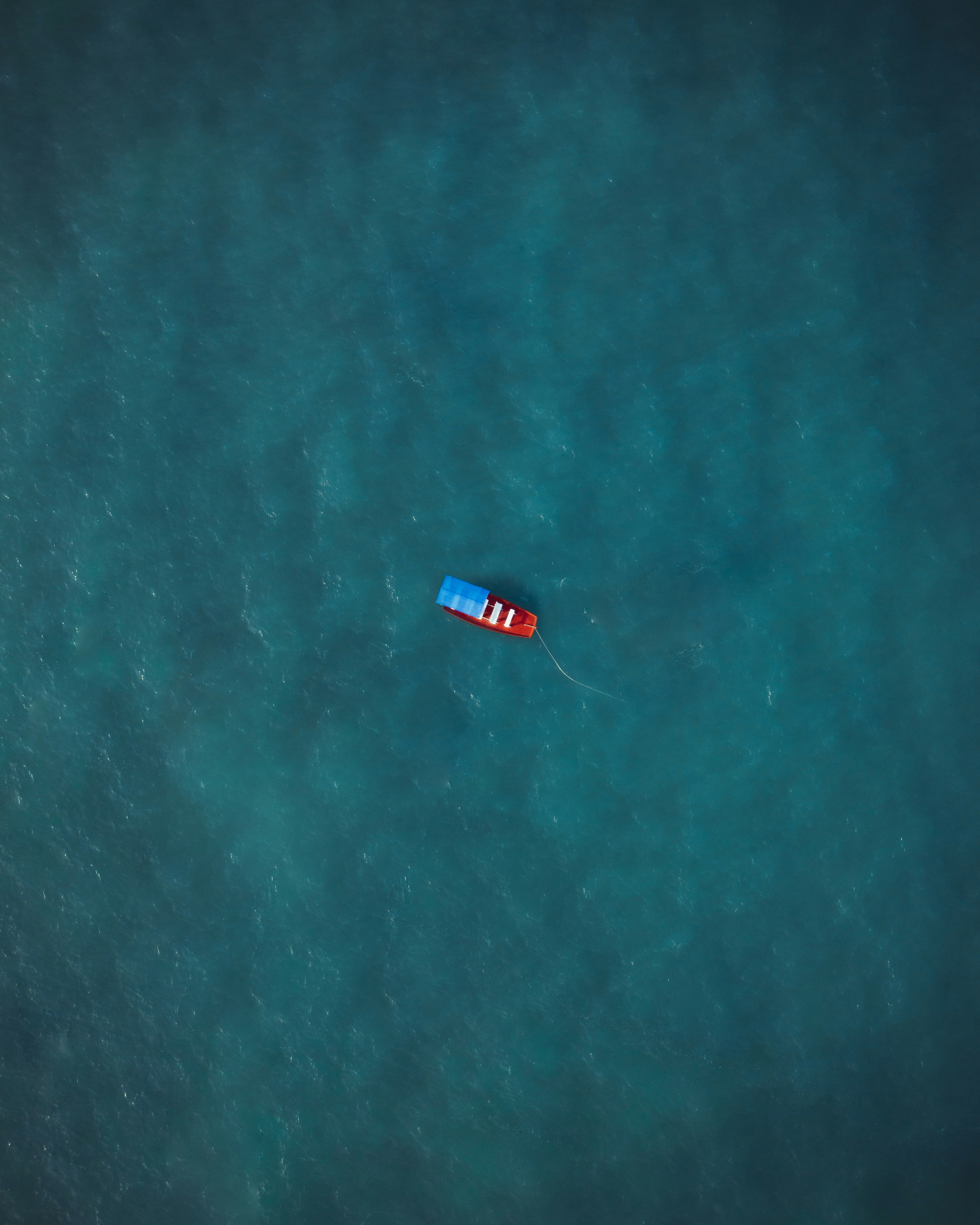 red boat on body of water during daytime