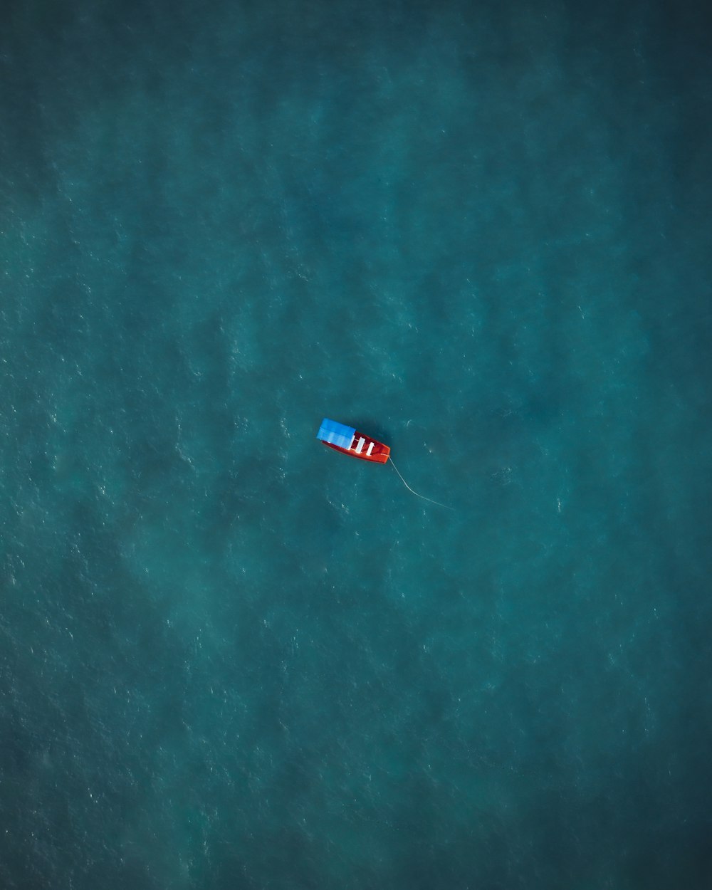 red boat on body of water during daytime