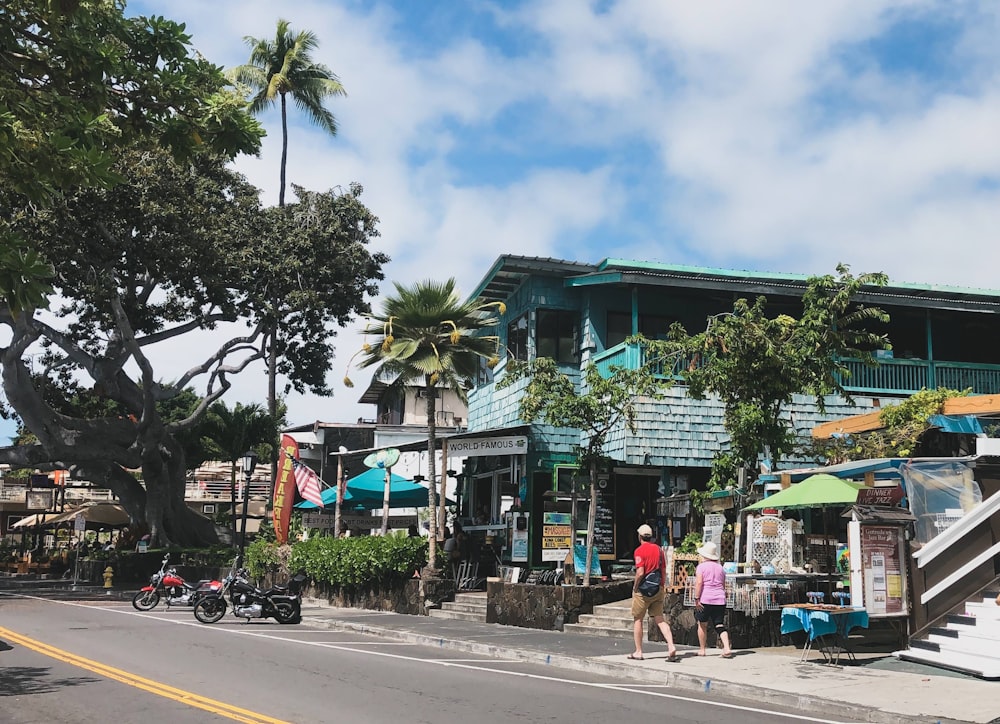 people walking on street near green and white building during daytime