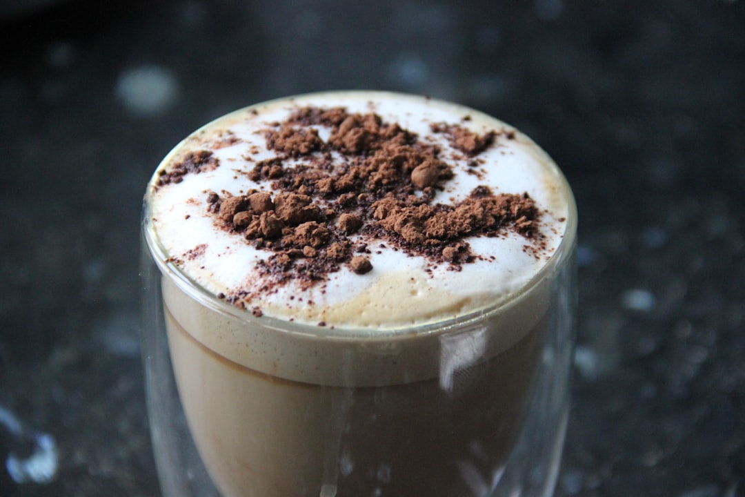Delicious Cappuccino with chocolate powder on dark background