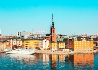 white boat on water near city buildings during daytime