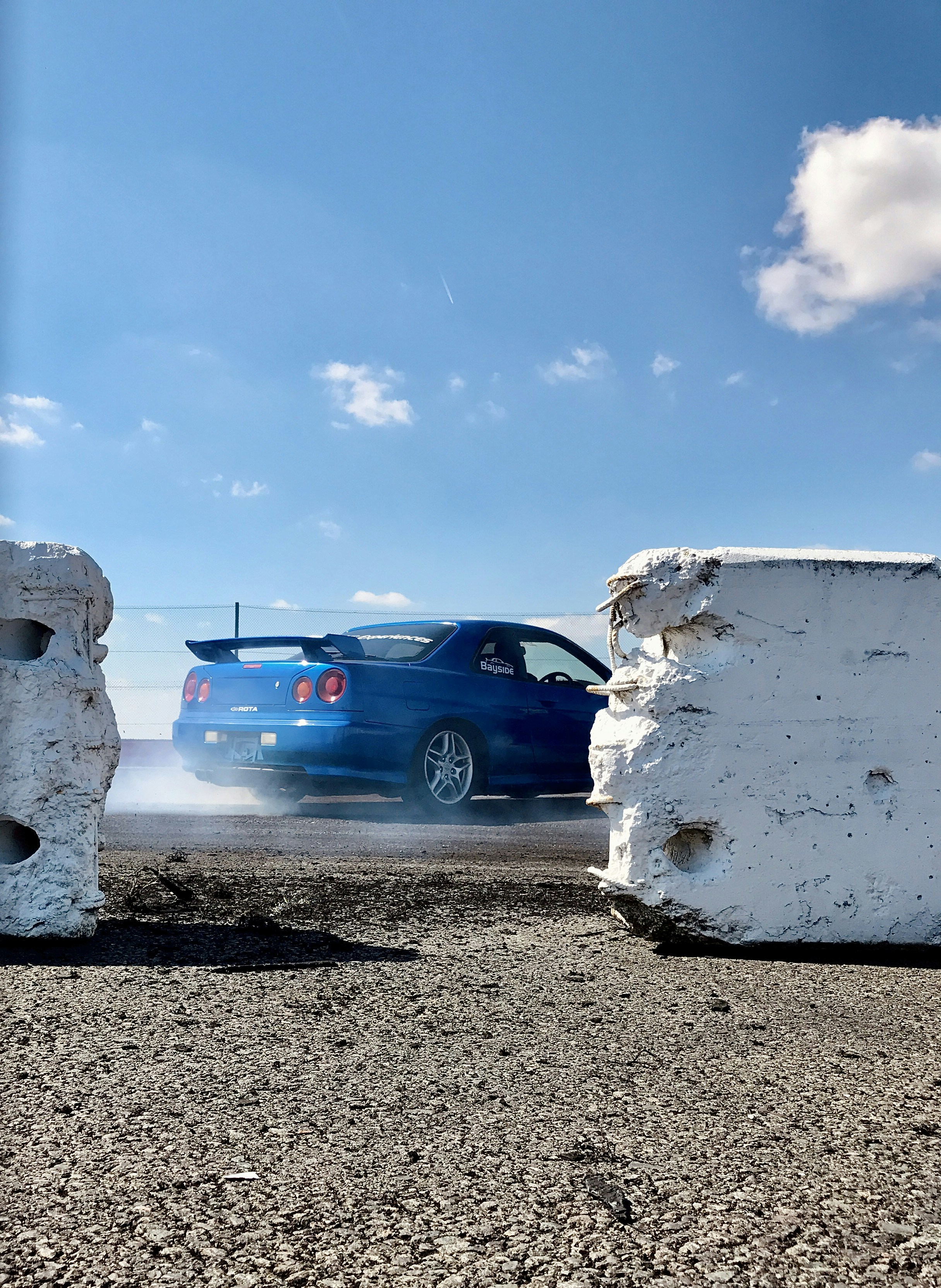 Blaues Chevrolet-Auto neben weißer Wand geparkt