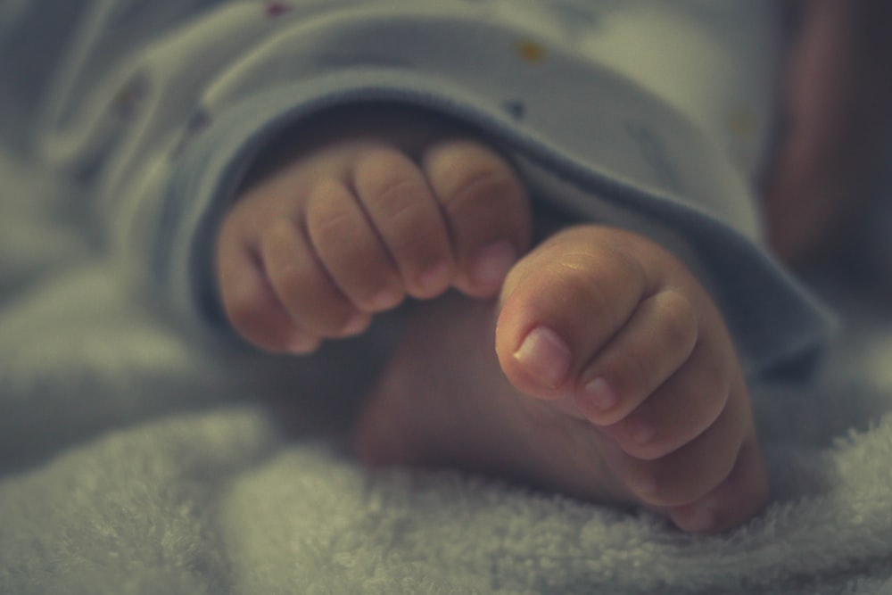 person holding babys foot