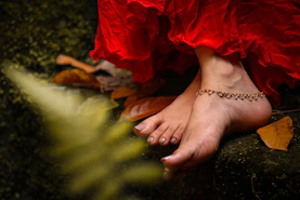 person wearing gold bracelet and red dress