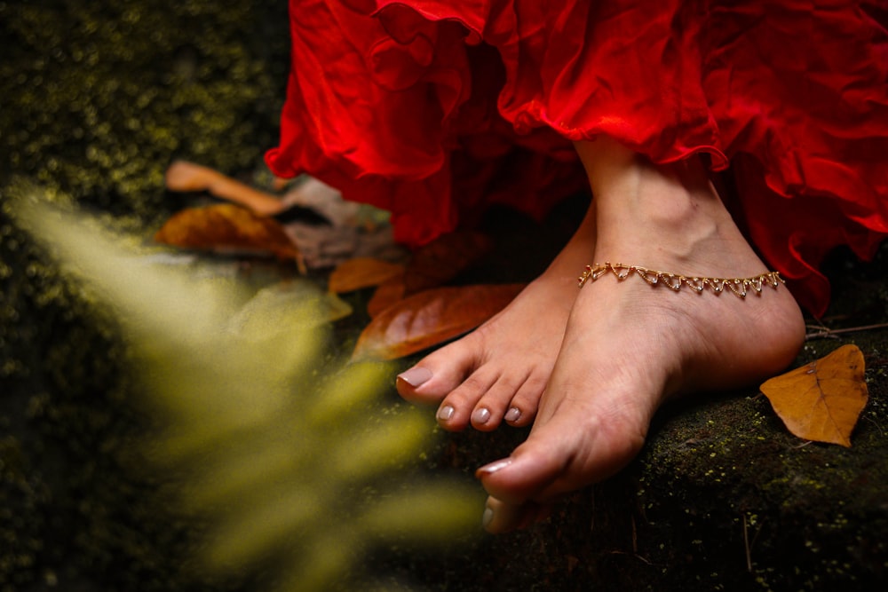 person wearing gold bracelet and red dress