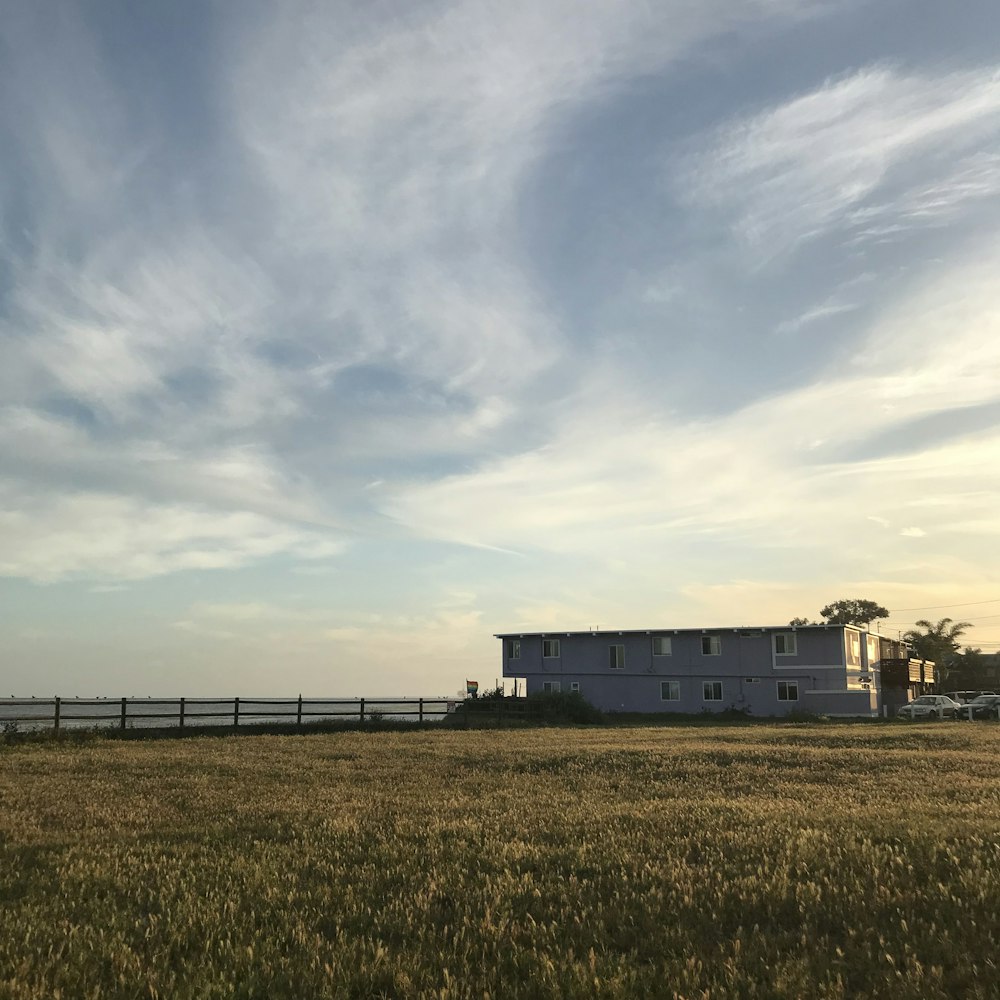 white and brown house under white clouds and blue sky during daytime