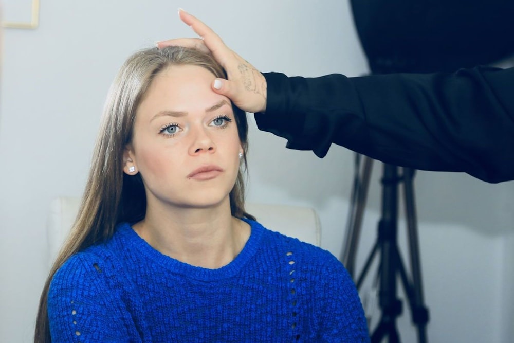 a woman getting her hair styled by a hair stylist