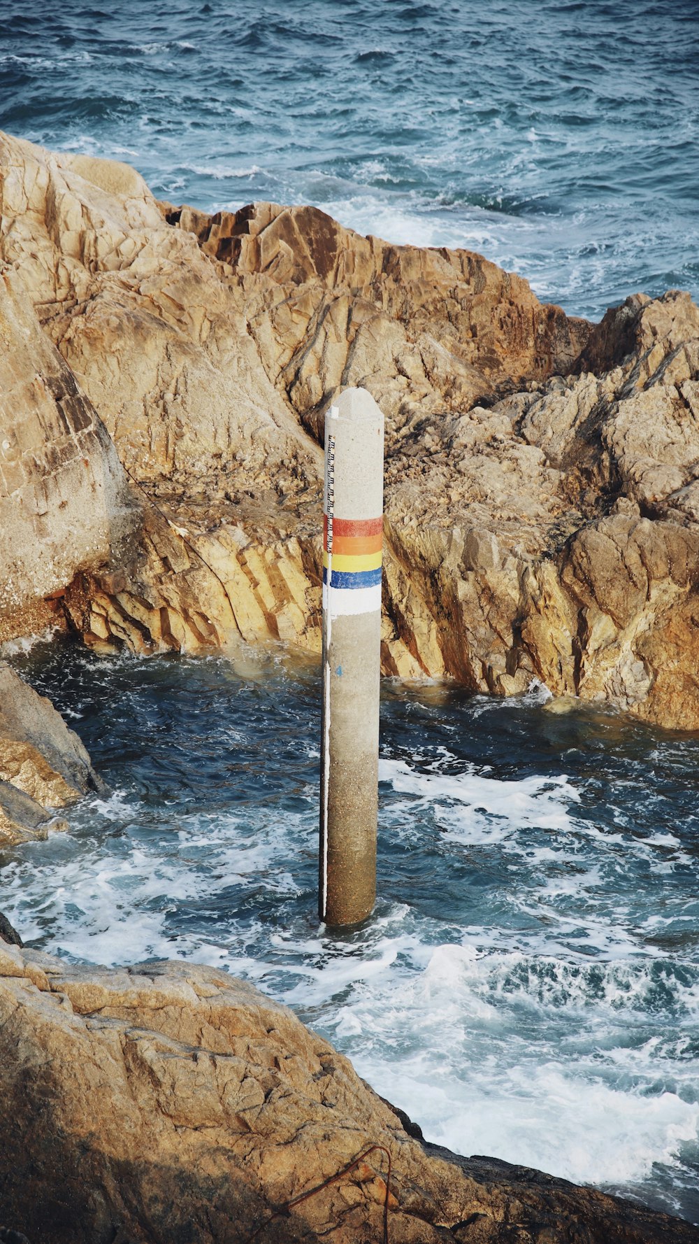 white and red lighthouse near body of water during daytime