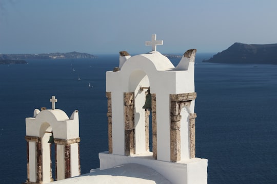 white concrete cross on white concrete wall in Santorini Greece