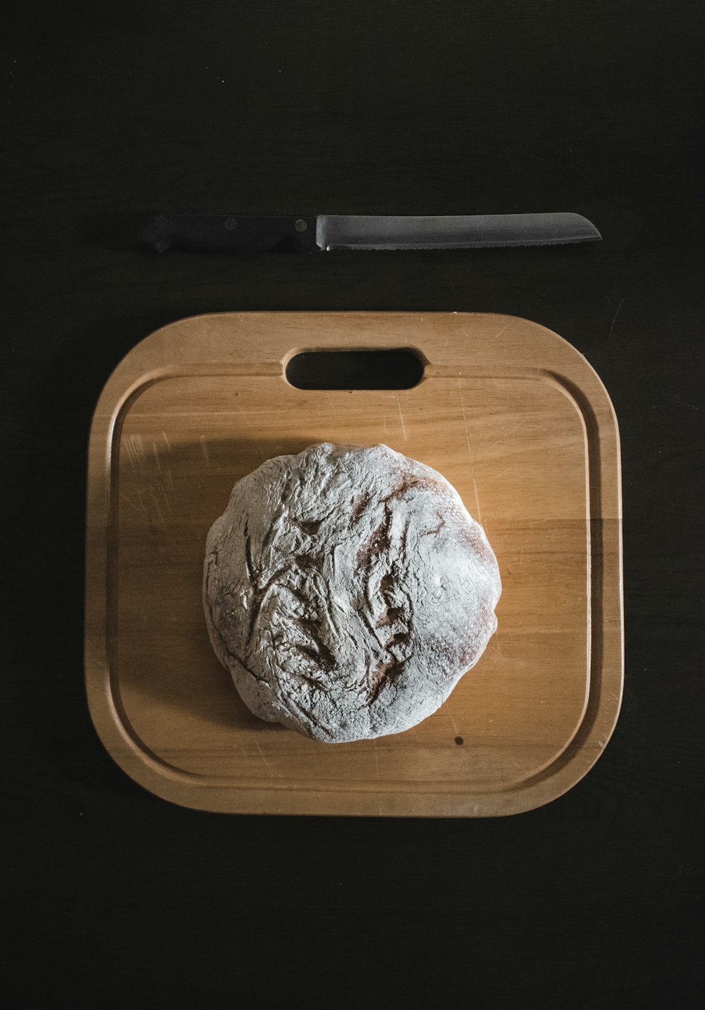 white and brown round bread on brown wooden chopping board