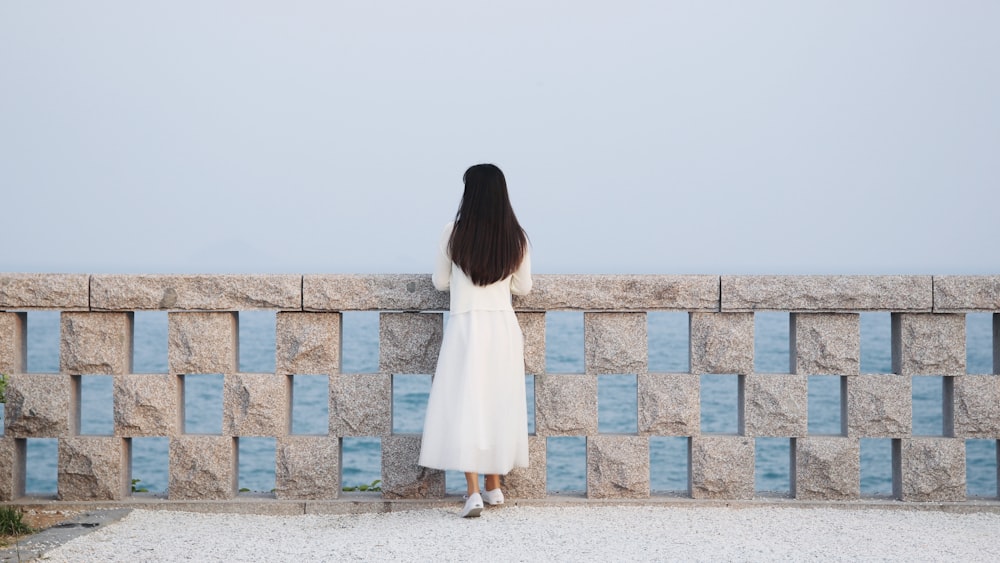 woman in white dress standing on concrete blocks during daytime