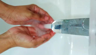 Close-up of clear water flowing from a newly installed tap with hands cupping the water