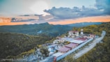 Sunset view over traditional Andean bungalows surrounded by lush green hills.