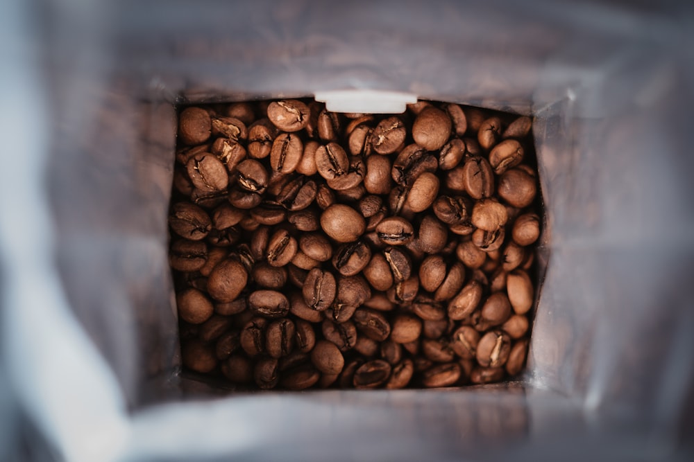 Granos de café marrón en paquete de plástico transparente