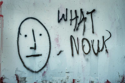 A painted face beside the words “What now”