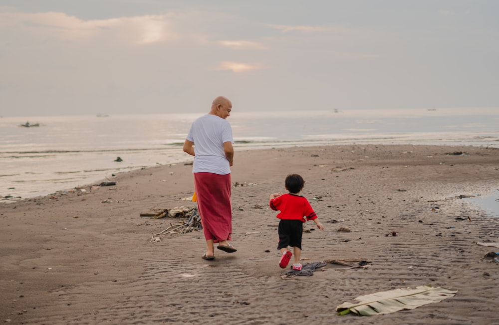 man in white t-shirt and red shorts standing on beach during daytime