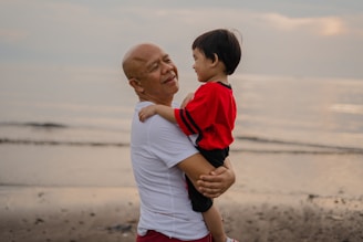 man in white and red polo shirt carrying boy in white and red shirt