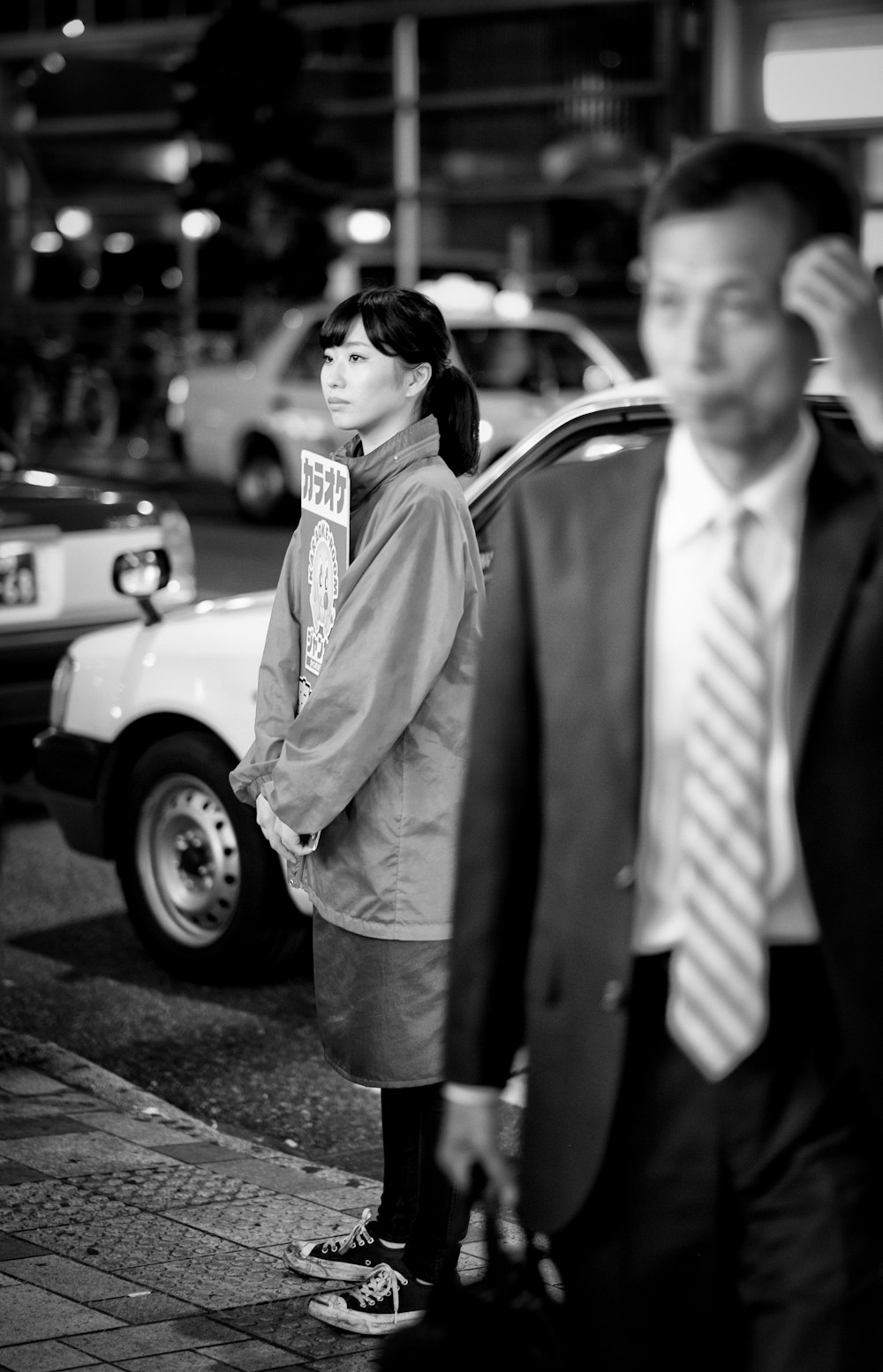 man in black and white striped necktie and gray coat standing beside woman in white coat