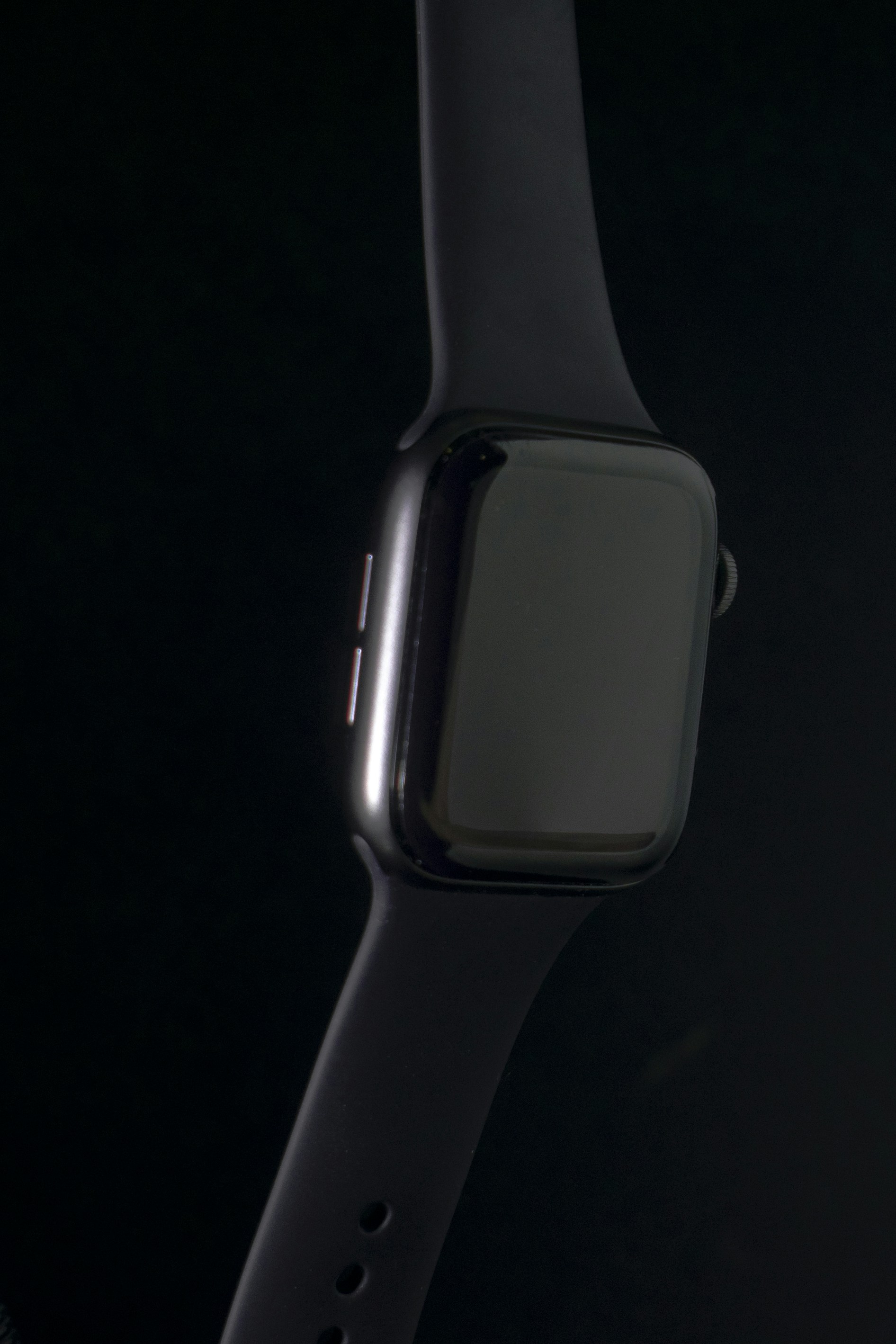 Apple Watch Series on dark background showing watch face with dark sport band