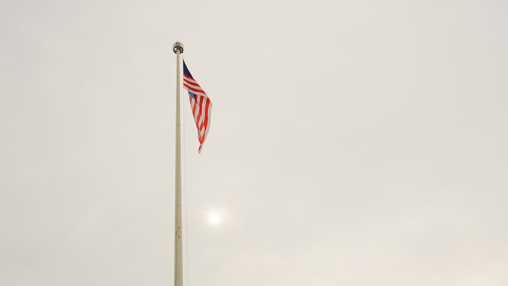 us a flag on pole under white sky during daytime
