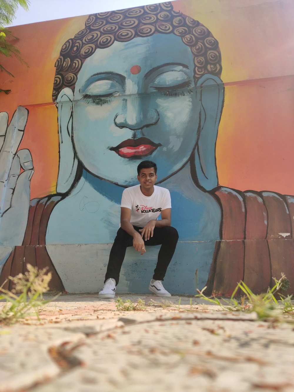 woman in blue t-shirt and black pants standing beside wall with graffiti