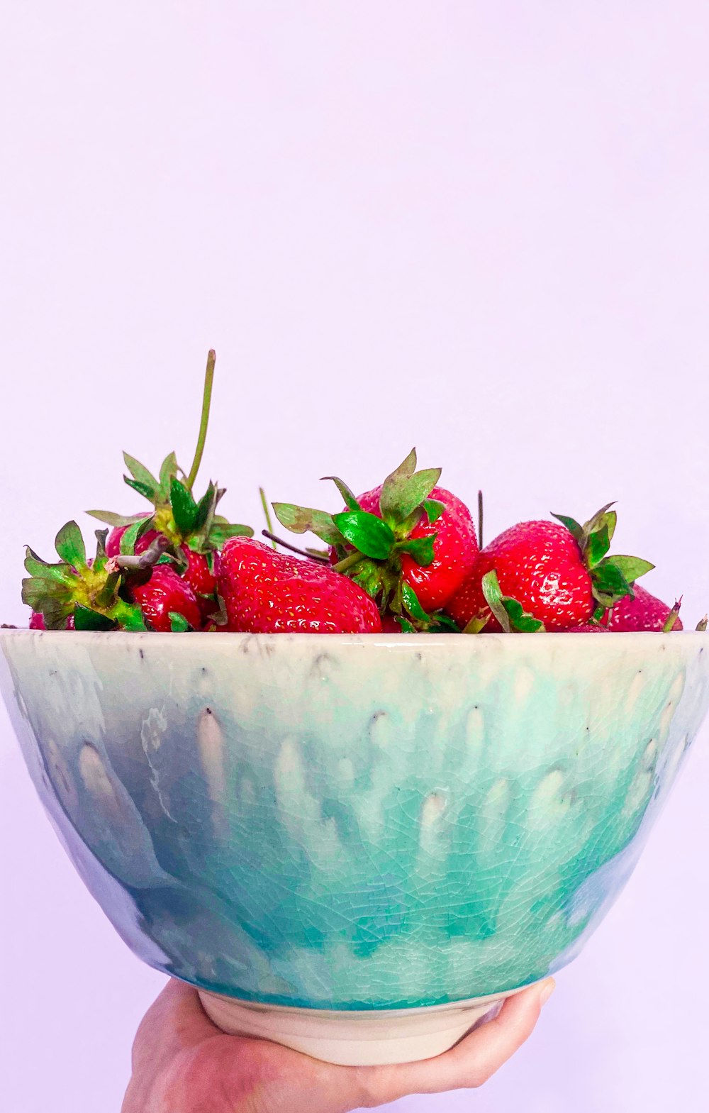 strawberries in teal ceramic bowl