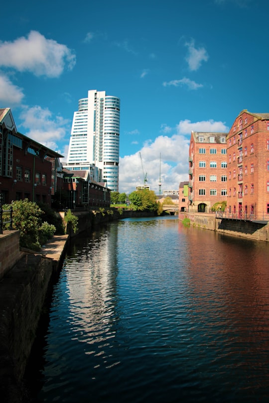 brown concrete building near river during daytime in Leeds United Kingdom