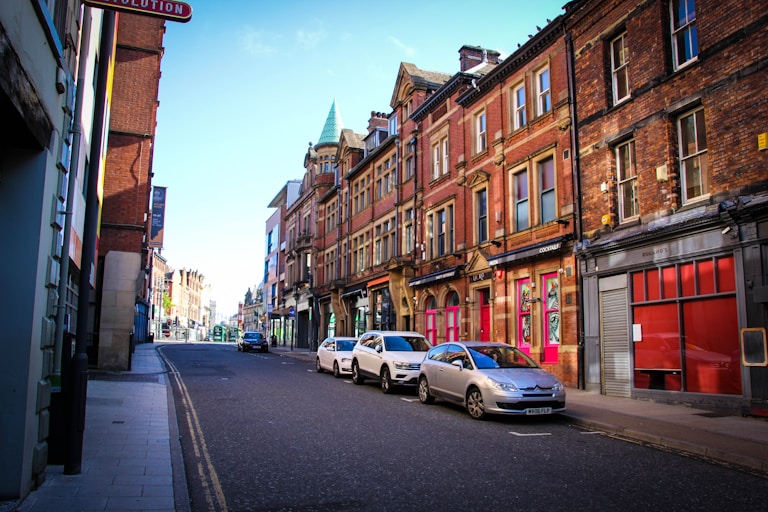 cars parked on side of the road near buildings during daytime