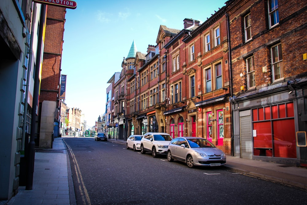 cars parked on side of the road near buildings during daytime