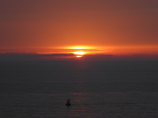 silhouette of two people on body of water during sunset in Zoutelande Netherlands